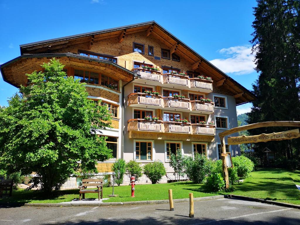 ein großes Gebäude mit Balkon auf der Seite in der Unterkunft Ribno Alpine Hotel in Bled