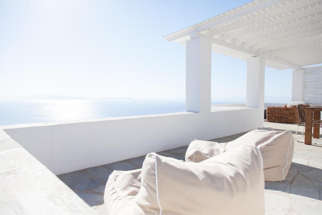 een woonkamer met witte meubels en uitzicht op de oceaan bij Astarte Luxury Apartments in Artemonas