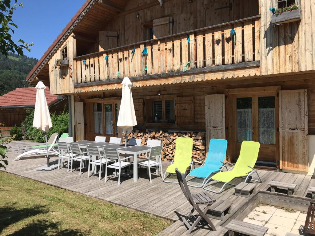 una terrazza con tavolo, sedie e un edificio di Chalet La Grande Ourse a Saint-Gervais-les-Bains