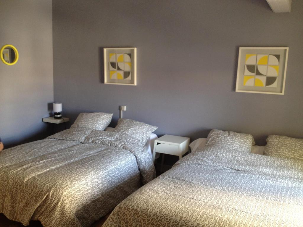 1 dormitorio con 2 camas y 2 cuadros en la pared en L'ISLE, en Beaucaire
