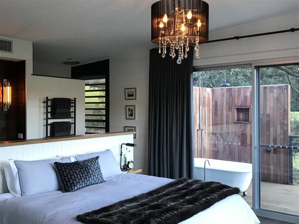 um quarto com uma cama e um lustre em Amaroo Valley Springs em Barrengarry