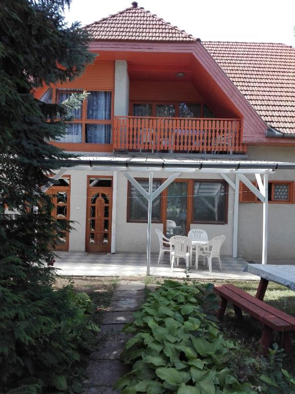 a house with a deck and a table and chairs at Hutter Vendégház in Szántód