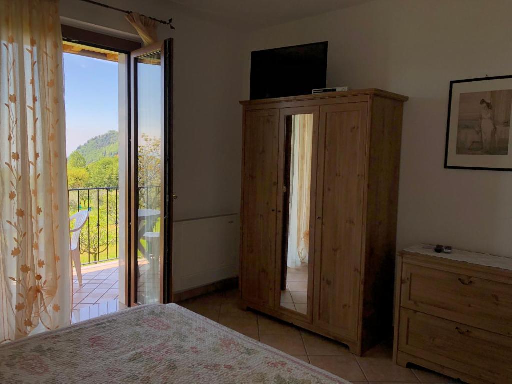 1 dormitorio con 1 cama y puerta corredera de cristal en Garnì Marika en Gargnano