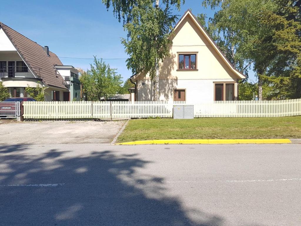 a white house with a white picket fence at Rannakorterid Pärnu rannas in Pärnu