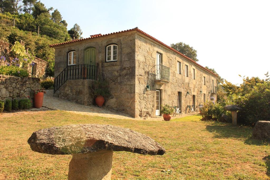 un gran edificio de piedra con una piedra en Quinta de Favaes, en Paredes de Coura