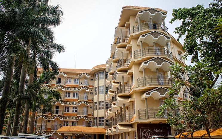 a large apartment building with cars parked in front of it at Hotel Sonar Bangla Tarapith in Tarapith