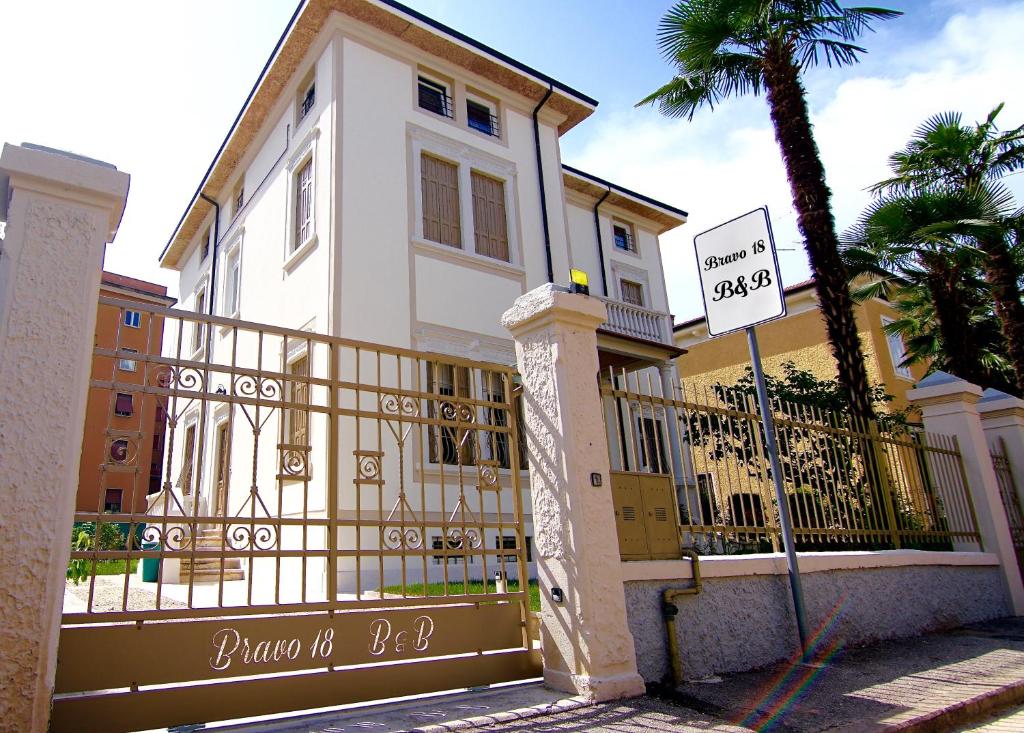 une maison blanche avec un panneau devant elle dans l'établissement Bravo 18, à Vérone