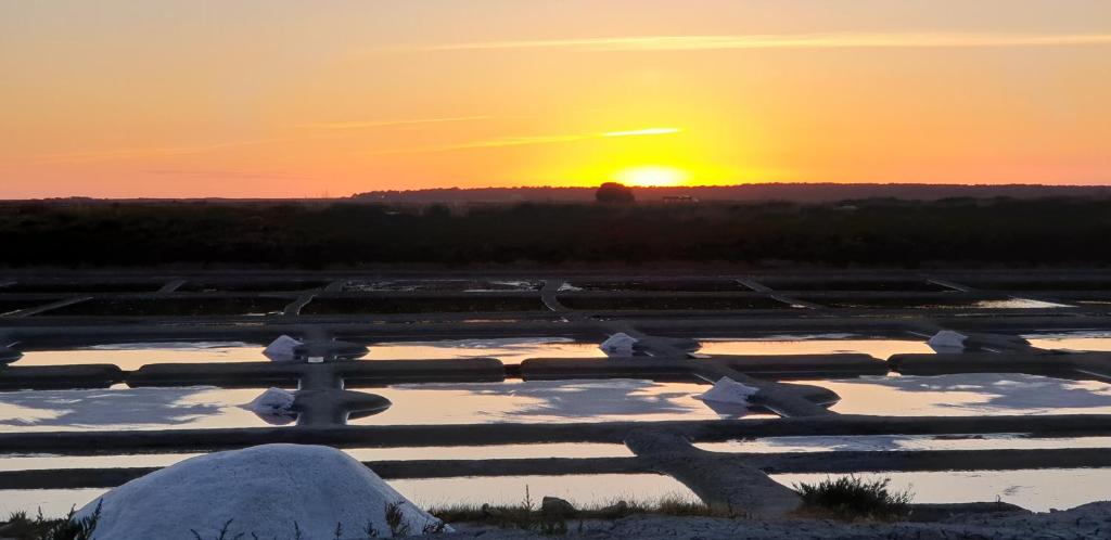 um pôr-do-sol sobre um campo coberto de neve com o sol ao fundo em Kerstunt Chambre d'hôtes Relais Motards em Guérande