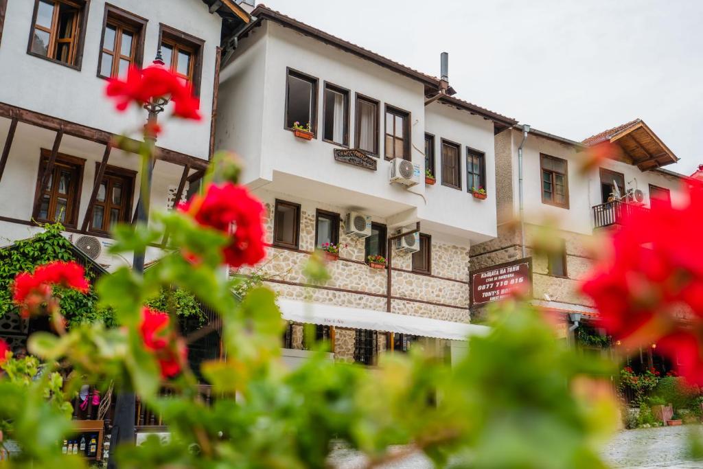 a building with red flowers in front of it at Toni's Guest House in Melnik