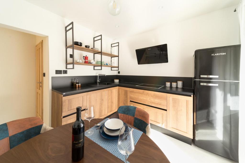 uma cozinha com uma mesa de madeira e um frigorífico preto em Impression em Mošćenička Draga