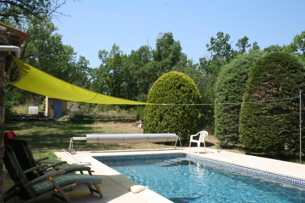 a swimming pool with a yellow towel hanging over it at Les Rochers in Saint-Étienne-de-Gourgas