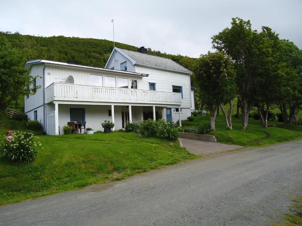 a white house on the side of a road at Peaceful Farm in Bøstad