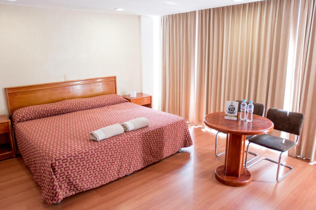 a hotel room with a bed with a table and a table at Hotel San Francisco Centro Histórico in Mexico City