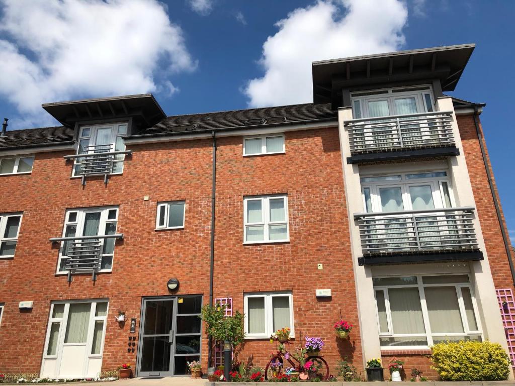 a red brick building with windows and balconies at Contractor Stays I Long Stay Offer I Gated Parking I WIFI I Workspace I PRIDE APARTMENTS in Derby