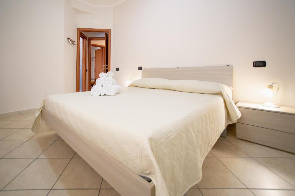 a bedroom with a white bed with a teddy bear on it at B&B Nonno Michele in Fisciano