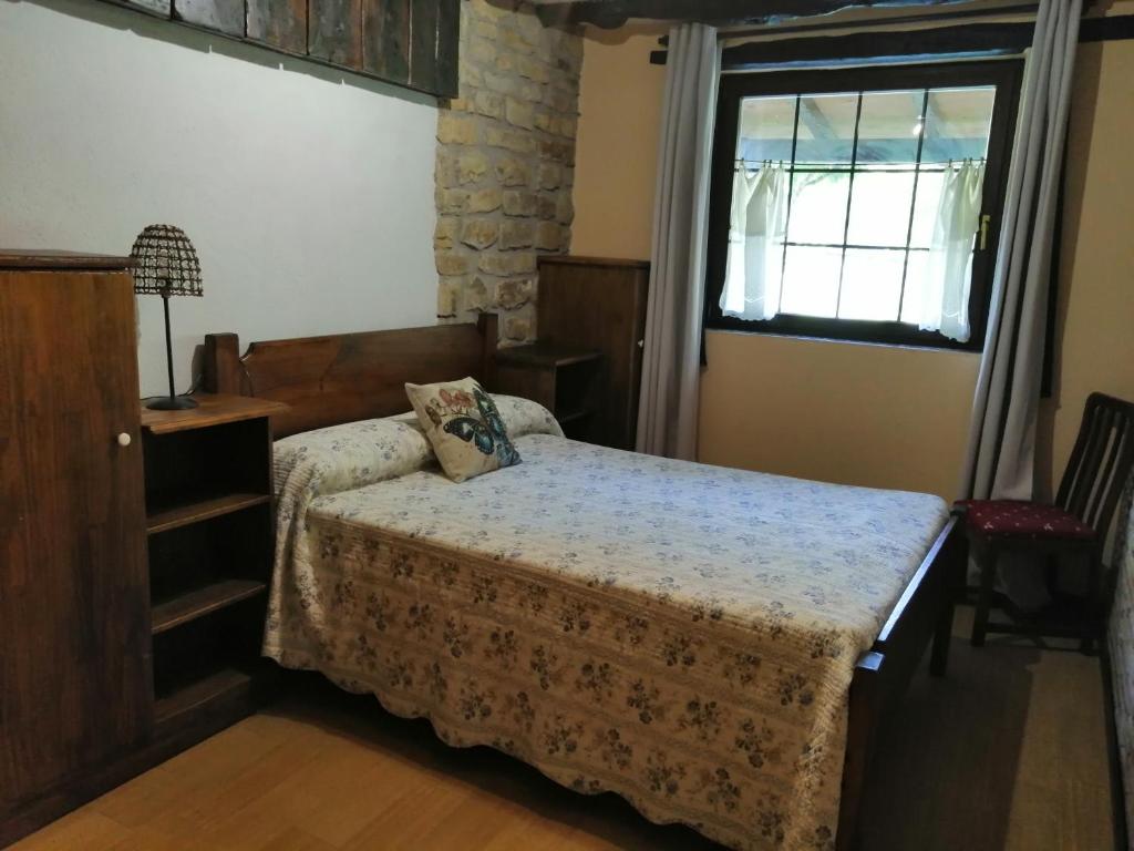 1 dormitorio con cama y ventana en Iturbe1, en Busturia