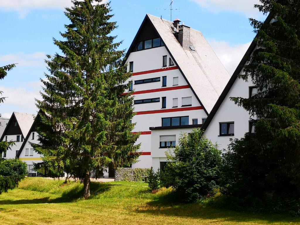 een wit gebouw met een boom ervoor bij Ferienwohnung Lydia in Schönwald