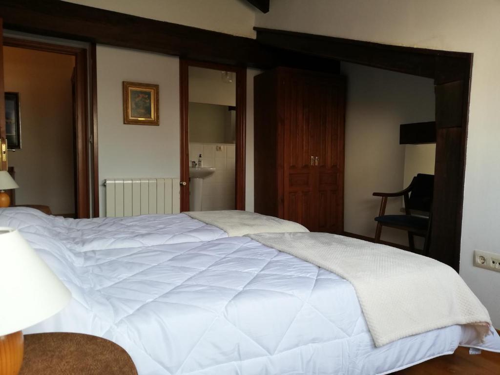 a bedroom with a large white bed in a room at La Carriella in Colombres