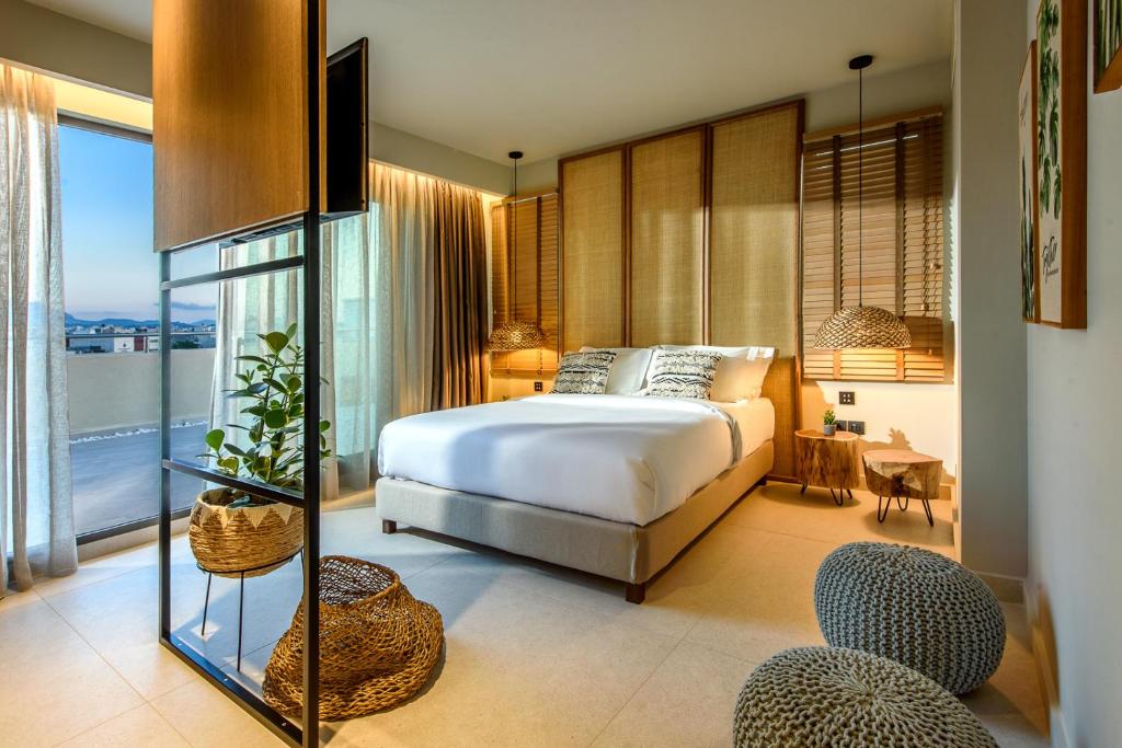sypialnia z łóżkiem i dużym oknem w obiekcie DOM Boutique Hotel w Heraklionie
