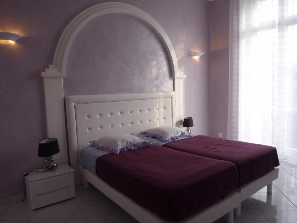 a bedroom with a large bed with a purple blanket at Palais Augusta- CAT3615- 2Bedrooms in Cannes
