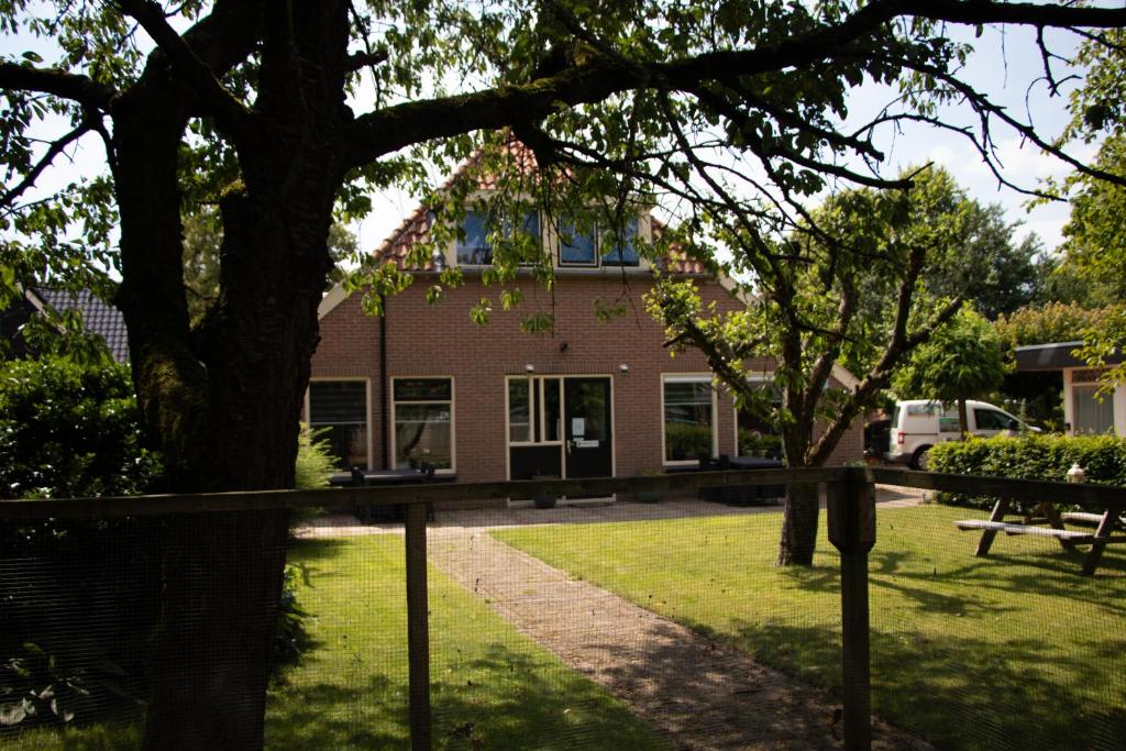 un edificio con un árbol delante de él en Appartementen Aangenaam - Olde Horst Diever, en Diever