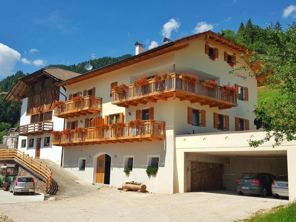 un gran edificio blanco con balcones y garaje en Mesnerhof, en Lauregno