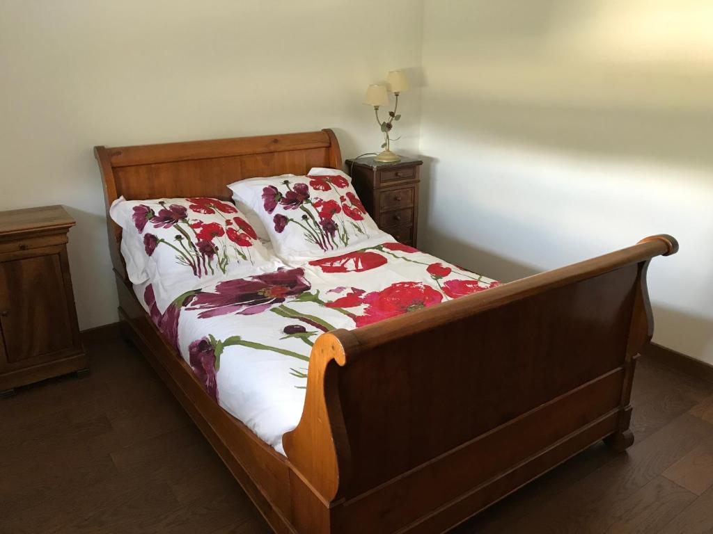 a bedroom with a bed with a floral bedspread at Aux coquelicots sauvages in Pont-Saint-Martin