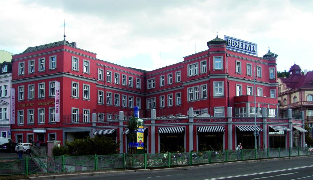 a large red building on the side of a street at Apartmany Becherplatz in Karlovy Vary
