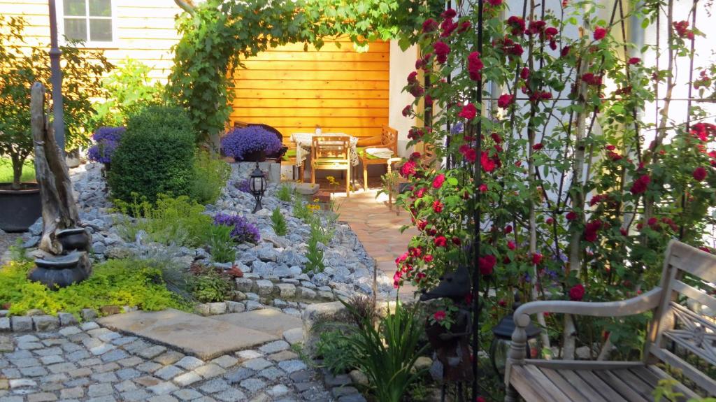einen Garten mit Blumen und einer Bank vor einem Haus in der Unterkunft Ferienwohnung Wolfsholz in Wernigerode