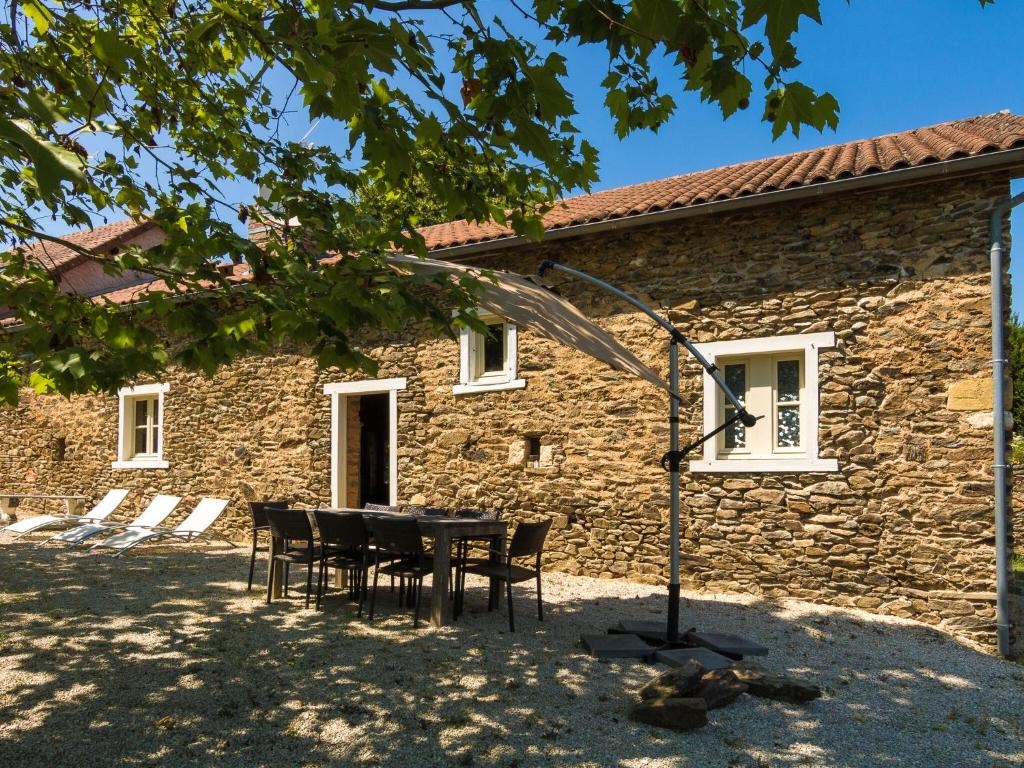 un tavolo e sedie di fronte a un edificio in pietra di Cottage in Chaleix near Forest & Lake a Chaleix
