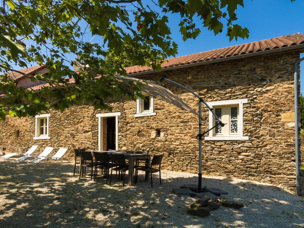 a table and chairs in front of a stone building at Modern Cottage in Chaleix with Swimming Pool in Chaleix