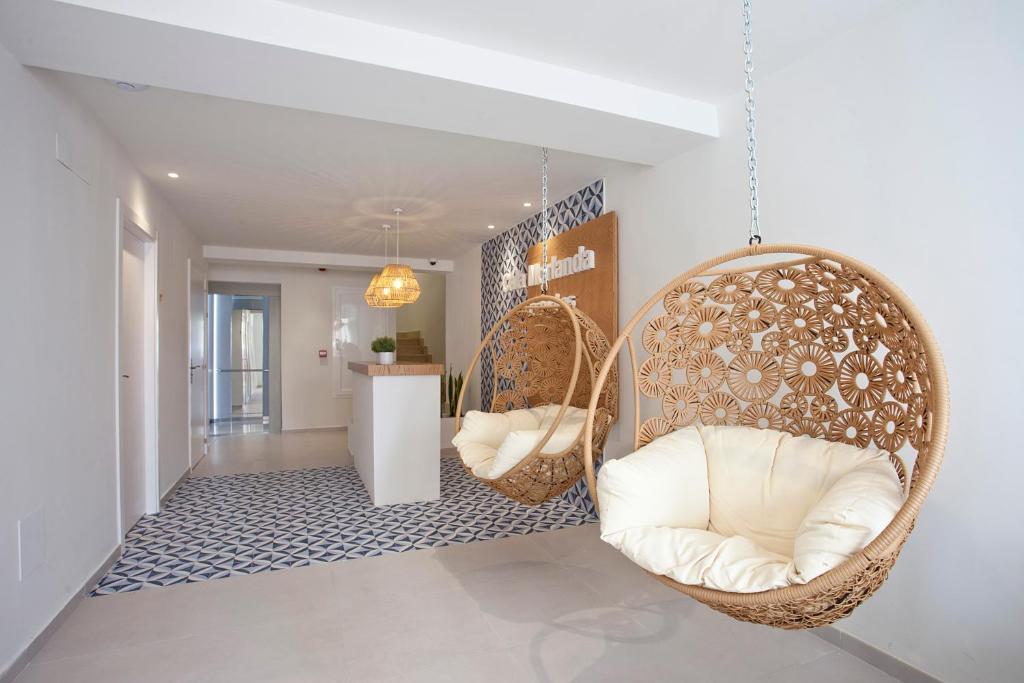 una habitación con 2 sillas colgantes y un pasillo en BJ Cala Morlanda Estudios en S'Illot