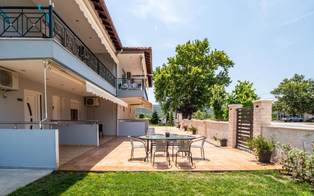 a patio with a table and chairs in a backyard at A Ponte Studios & Apartments in Sykia Chalkidikis