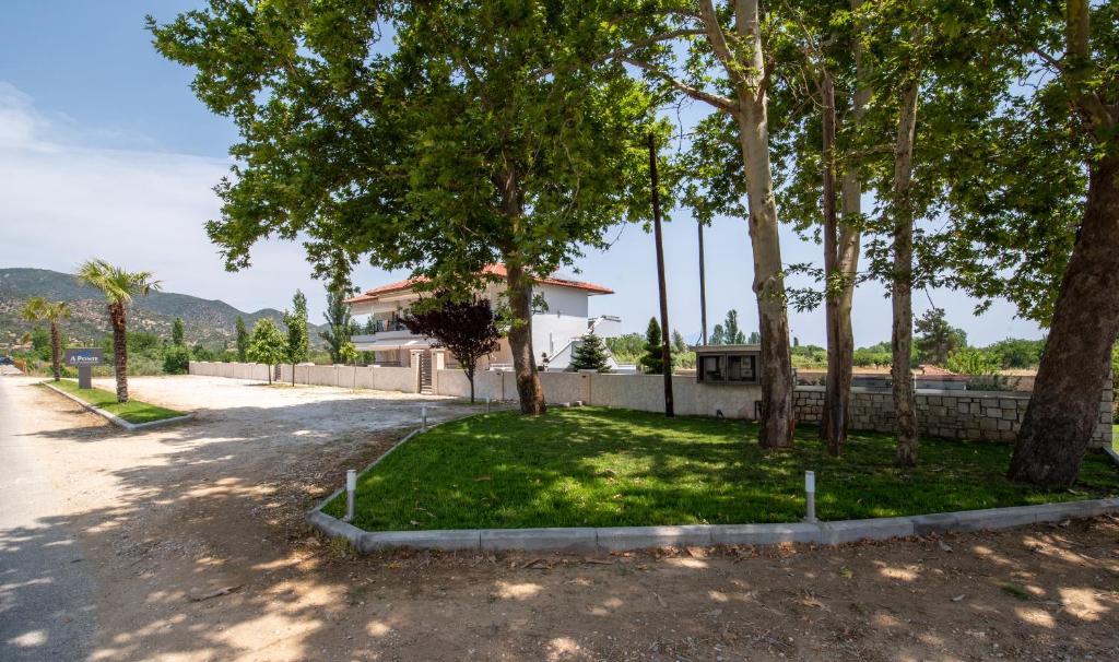 a house with a yard with trees and a driveway at A Ponte Studios & Apartments in Sykia Chalkidikis