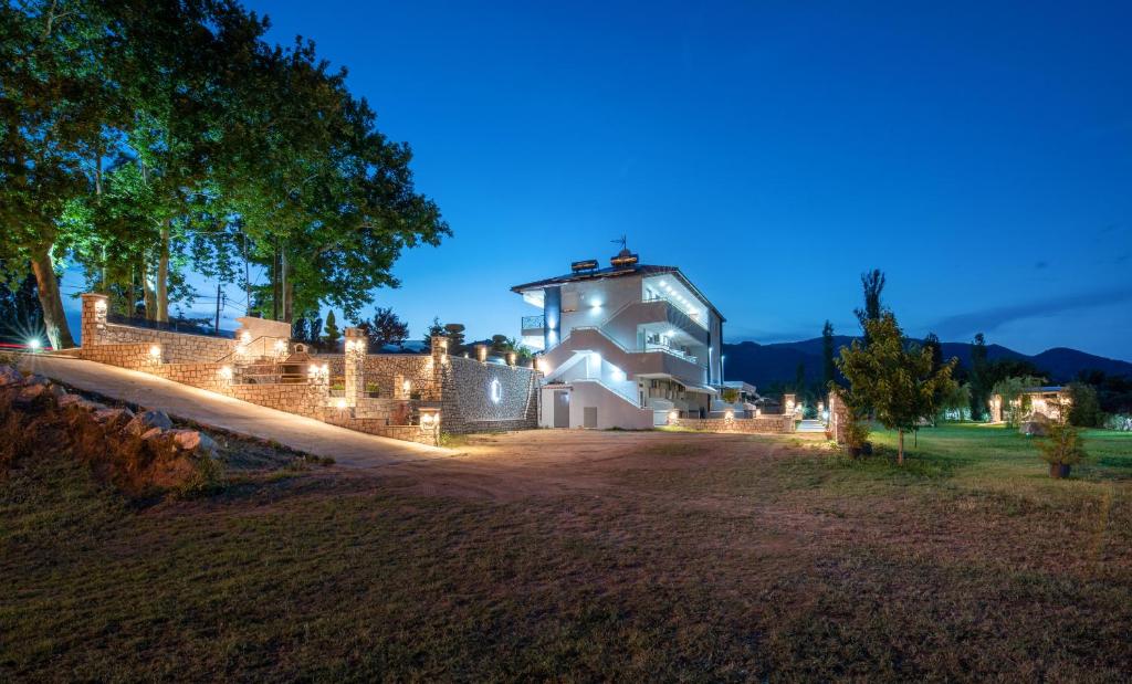 a house with lights on the side of it at night at A Ponte Studios & Apartments in Sykia Chalkidikis