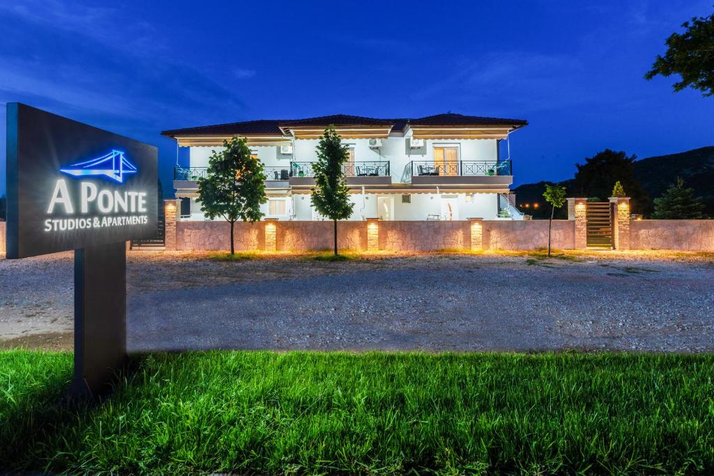 a sign in front of a house at night at A Ponte Studios & Apartments in Sykia Chalkidikis