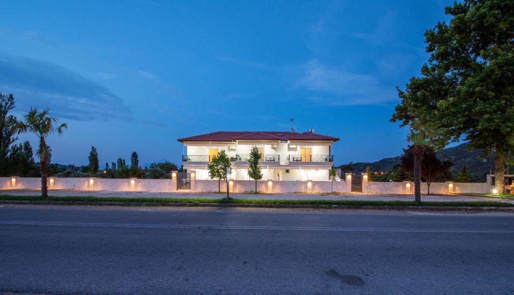 a white house with lights on the side of a street at A Ponte Studios & Apartments in Sykia Chalkidikis