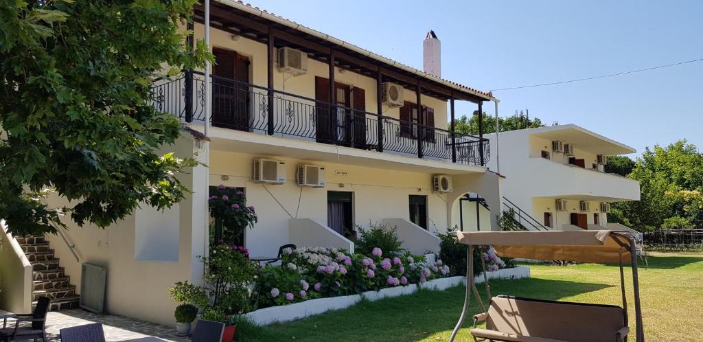 a large white building with balconies and a yard at Dream House in Agia Paraskevi
