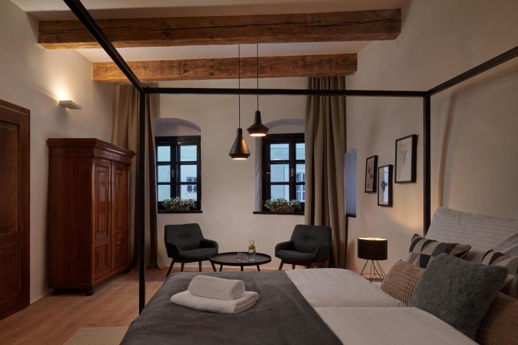 a bedroom with a bed and two chairs and a table at Pension Kristian by KH in Český Krumlov