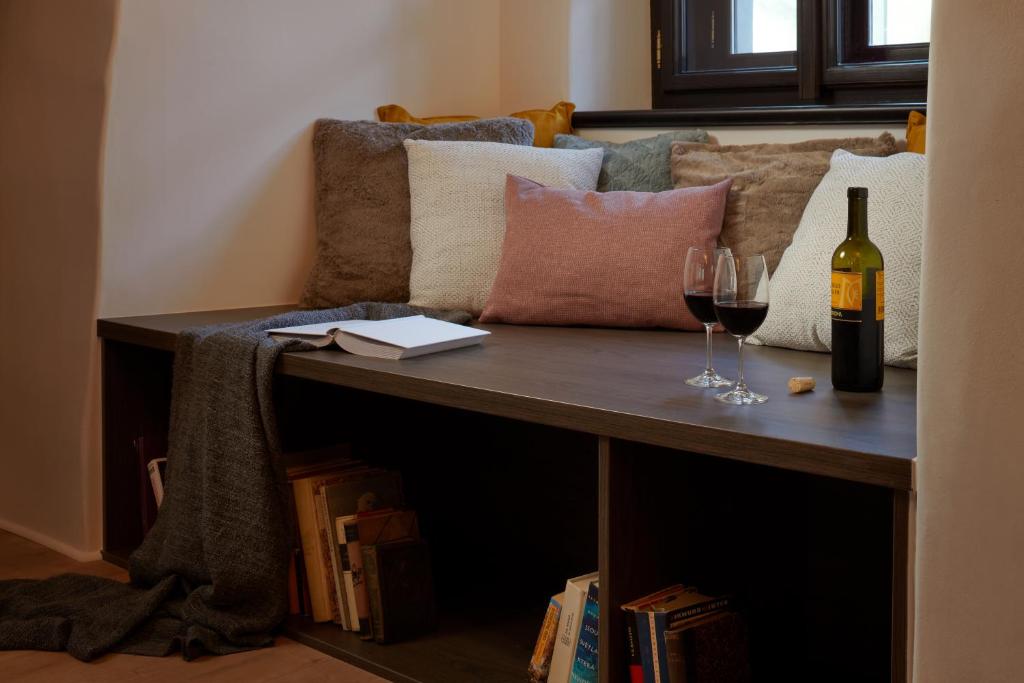 a couch with pillows and a bottle and glasses of wine at Pension Kristian by KH in Český Krumlov