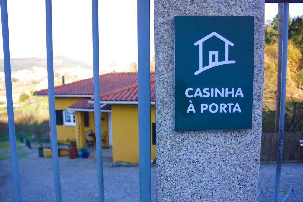 a sign for a house in front of a building at Casinha à Porta in Arouca