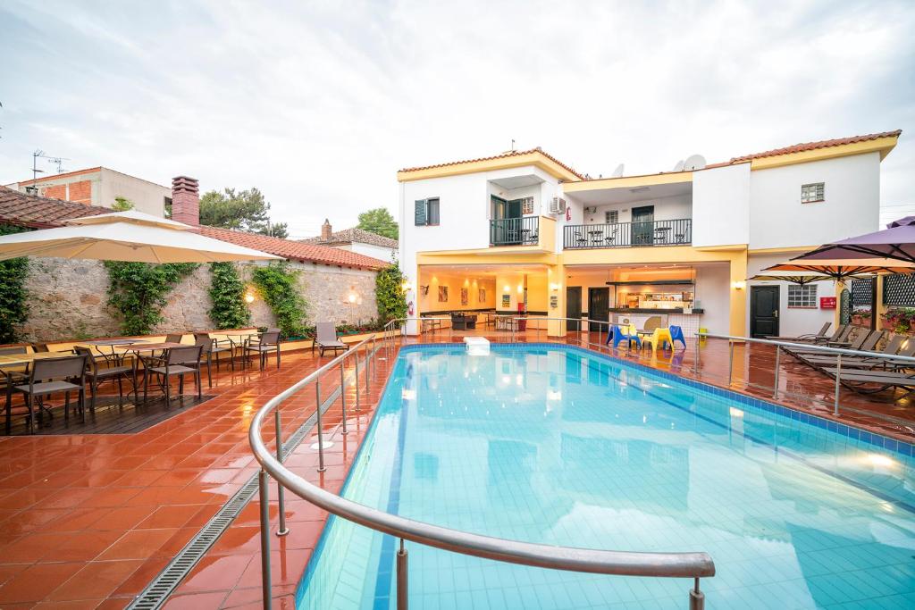 a swimming pool in a villa with tables and chairs at Elia Apartments in Afitos