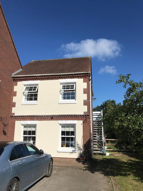 a house with a car parked in front of it at Moorhouse Farm Flat in Telford