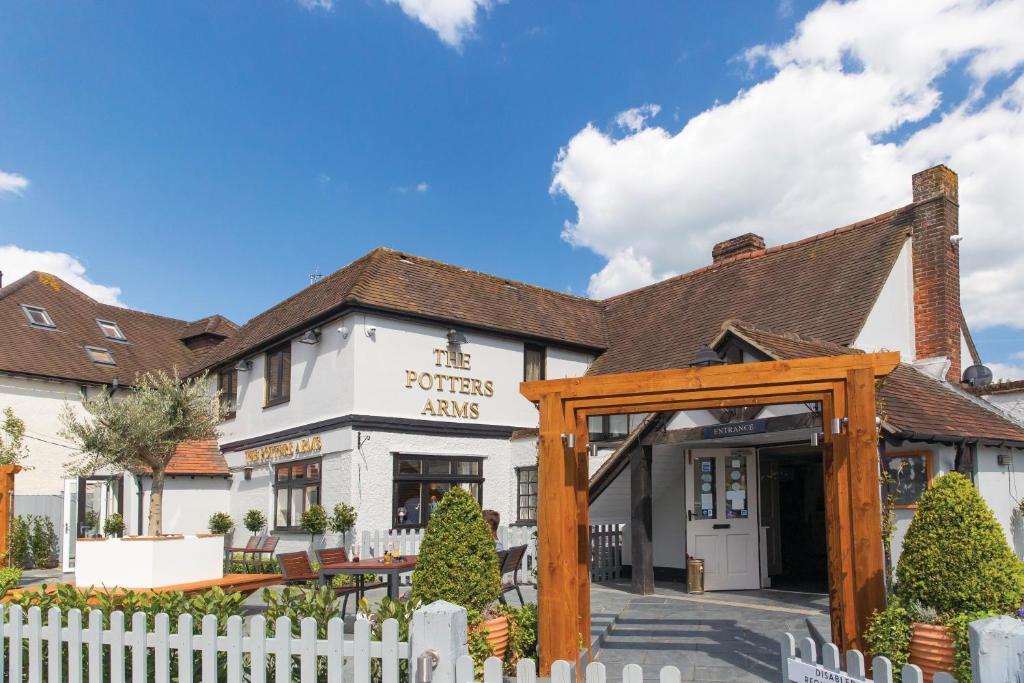 a pub with a white fence in front of a building at The Potters Arms in Amersham