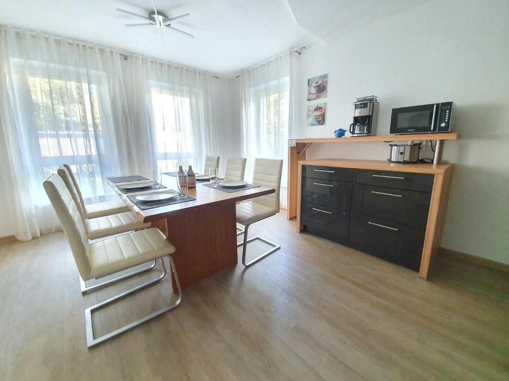 a room with a desk with chairs and a television at Apartment FALVIG inkl. Küche in Bad Schonborn