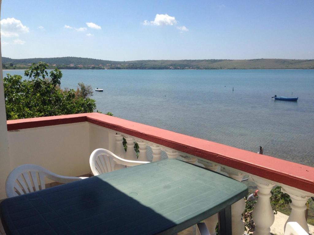 a balcony with a table and a view of the water at Villa M - 4 Persons Apartment, Put in Ljubač