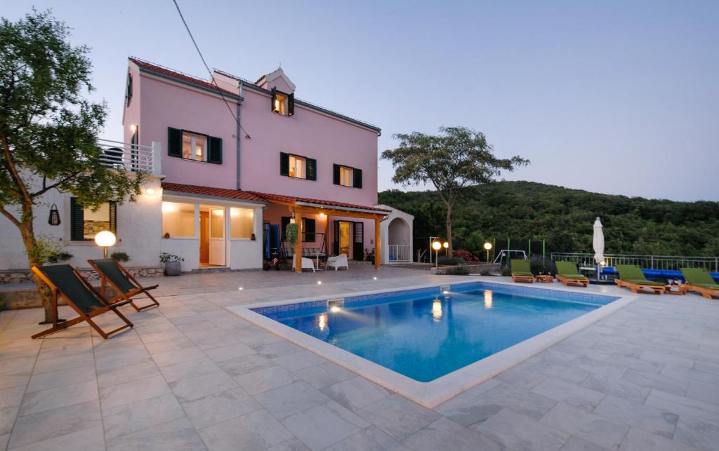 una villa con piscina frente a una casa en Holiday Home Koprivno, en Koprivno