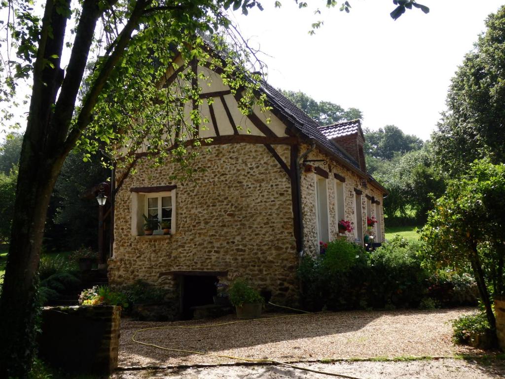 uma pequena casa de tijolos com uma janela e um quintal em Le Clos du Buisson em Saint-Julien-de-la-Liègue