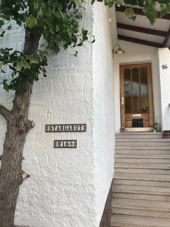 un cartello sul lato di un edificio con un albero di Ferienwohnung Stargardt Eimbeckhausen a Bad Münder am Deister