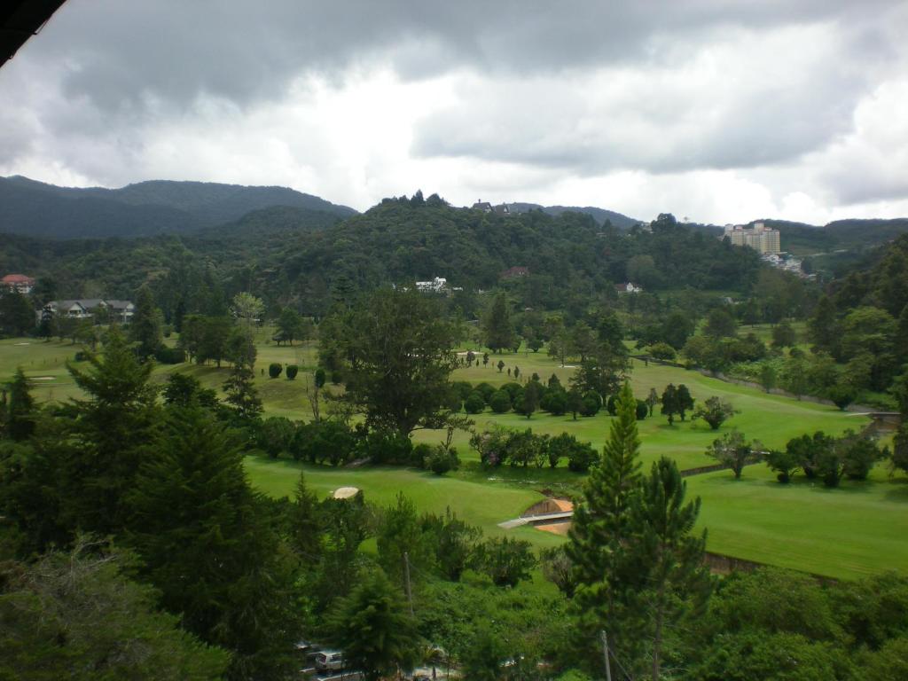 a view of a golf course with mountains in the background at CH Green Stay Resort Apartment in Cameron Highlands